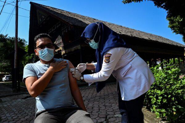  A man receives a booster shot of the Pfizer COVID-19 coronavirus vaccine at a makeshift clinic at the Aceh Museum in Banda Aceh on Jan. 17, 2022. (Chaideer Mahyuddin/AFP via Getty Images)