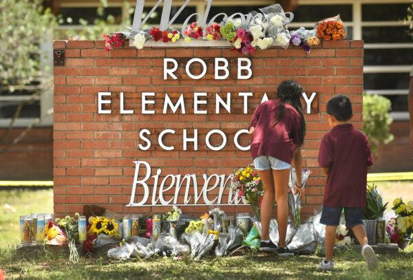 Family members who lost a sibling place flowers outside Robb Elementary School in Uvalde, Texas, on May 25, 2022. (Wally Skalij/Los Angeles Times via TNS)