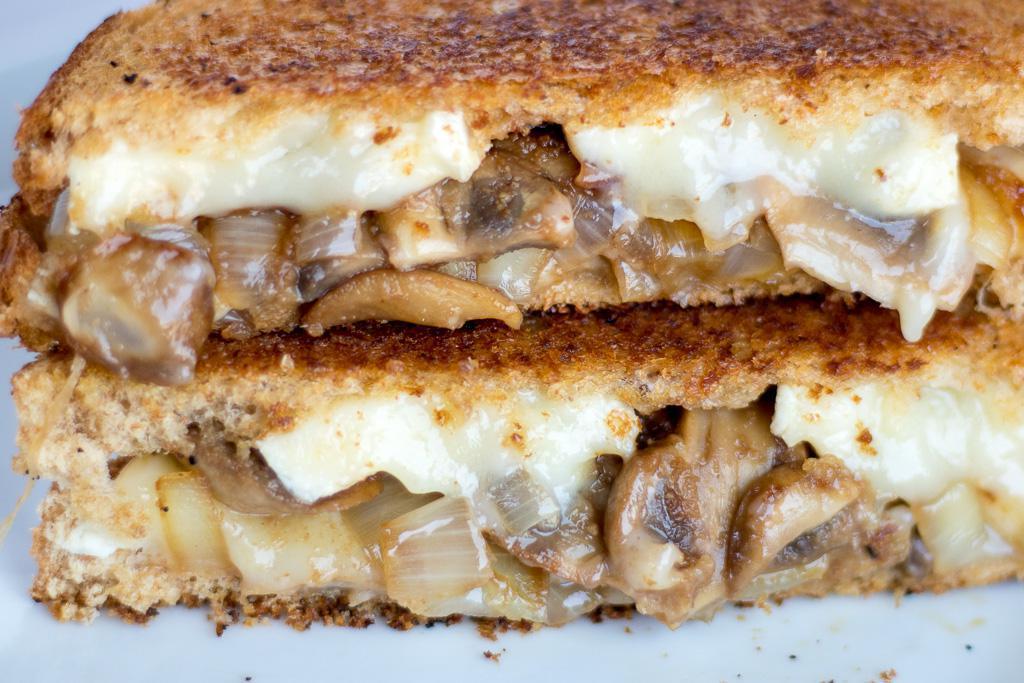 There may not be one tried-and-true trick for the most perfect golden crust on a grilled cheese, but a combination of butter and mayonnaise is as close as it gets. Out of the many ways to make a grilled cheese sandwich, this version with balsamic vinegar, mushrooms, caramelized onions and brie puts an atypical but scrumptious spin on brunch. (Photo courtesy of Bits and Bites) <a href="https://www.thedailymeal.com/best-recipes/balsamic-mushroom-onion-grilled-brie-cheese-sandwich">For the Balsamic, Mushroom and Onion Grilled Brie Cheese Sandwich recipe, click here</a>.