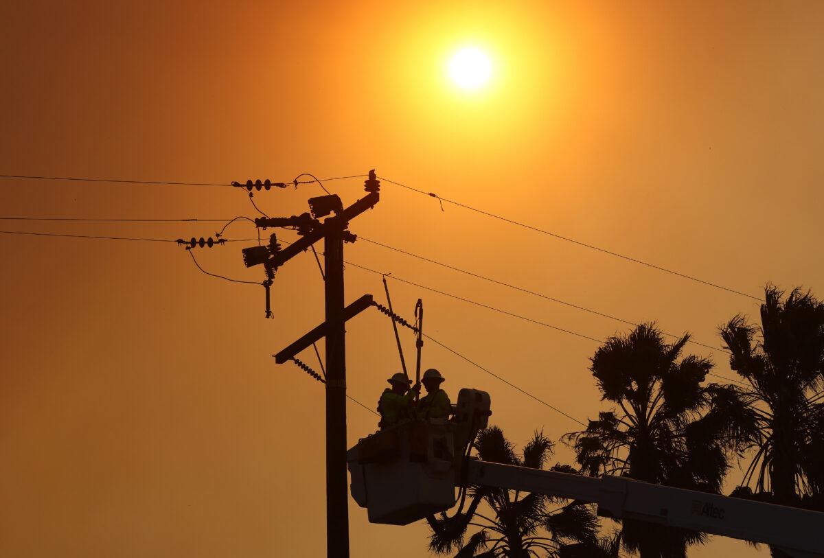 Workers repair damaged power lines near Irvine, Calif., on Dec. 3, 2020. (Mario Tama/Getty Images)