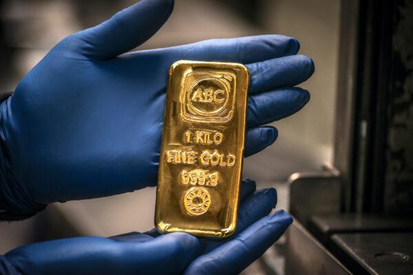 A worker displays a one kilogram gold bullion bar at the ABC Refinery in Sydney on August 5, 2020. (DAVID GRAY/AFP via Getty Images)