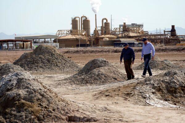Rod Colwell, CEO of Controlled Thermal Resources (R), and Tracy Sizemore, the company's global director of battery materials, walk along geothermal mud pots near the shore of the Salton Sea, where the company mines for lithium, in Niland, Calif., on July 15, 2021. (Marcio Jose Sanchez/AP Photo)