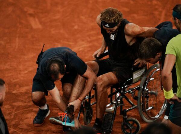 Germany's Alexander Zverev is carried into a wheelchair after twisting his ankle in the semifinal match against Spain's Rafael Nadal (R) at the French Open tennis tournament in Roland Garros stadium in Paris on June 3, 2022. (Thibault Camus/AP Photo)