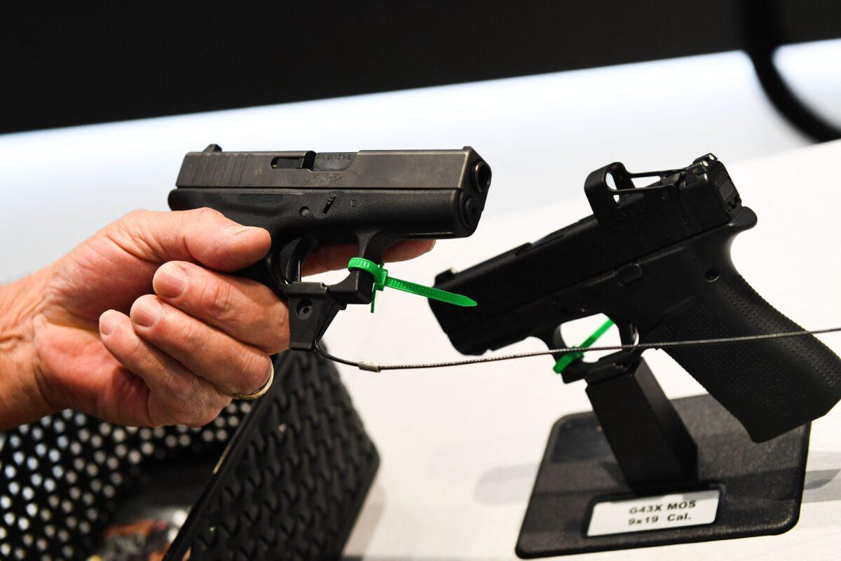 An attendee holds a Glock Ges.m.b.H. pistol during the National Rifle Association (NRA) Annual Meeting at the George R. Brown Convention Center, in Houston, Texas on May 28, 2022. (Patrick T. Fallon/AFP via Getty Images)
