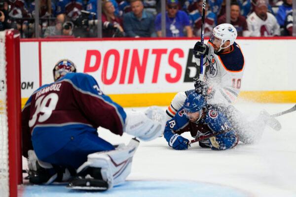 Edmonton Oilers center Derek Ryan (10) and Colorado Avalanche center Alex Newhook (18) tangle during the third period in Game 2 of the NHL hockey Stanley Cup playoffs Western Conference finals in Denver, on June 2, 2022. (AP Photo/Jack Dempsey)