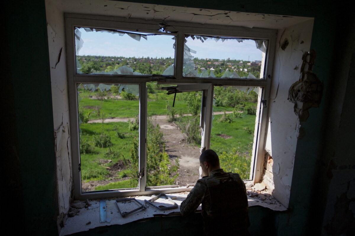 A Ukrainian serviceman inspects the area from a building damaged by a Russian military strike, in the town of Marinka, in Donetsk region, Ukraine, on May 28, 2022. (Anna Kudriavtseva/Reuters)
