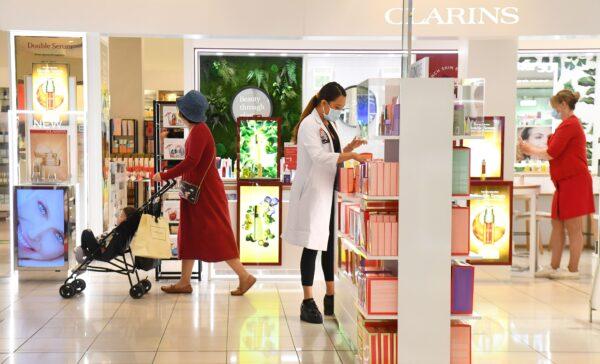 A woman walks past an employee at a department store in Melbourne, Australia, on Oct. 28, 2020. (William West/AFP via Getty Images)