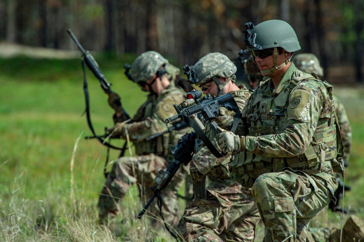 Members of the 182d Infantry Regiment load their weapons with live ammunition before heading into the field to train, firing on targets out in the field and working in concert with other squads, for deployment to the Middle East during live fire weapons training at US Fort Dix in New Jersey on May 16, 2022. (Joseph Prezioso /AFP via Getty Images)