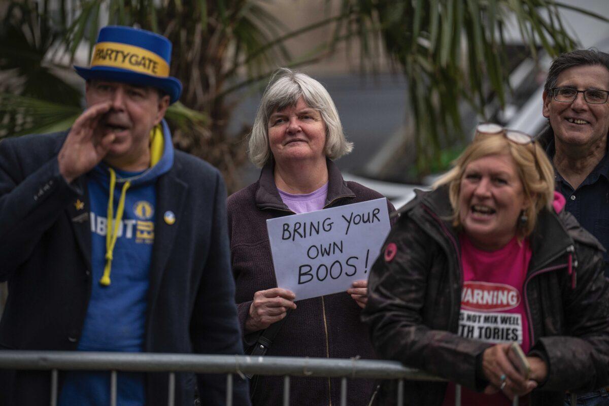 Activist Steven Bray stands next to a woman holding a placard mocking Boris Johnson as a pro-EU supporter protests near College Green in London on June 6, 2022. (Carl Court/Getty Images)