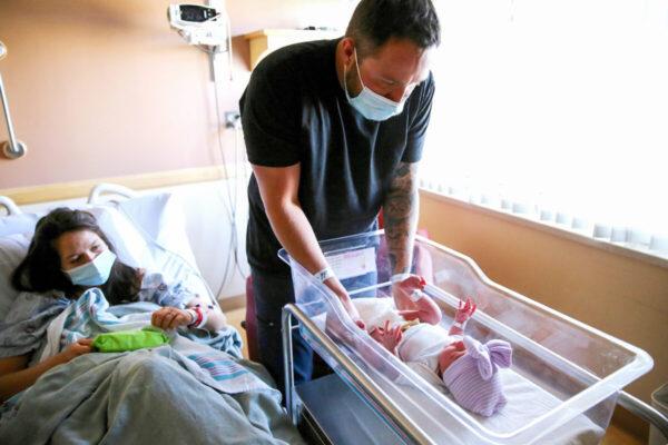 A father prepares to change the diaper of his newborn daughter as his wife looks on in a hospital. (Mario Tama/Getty Images)