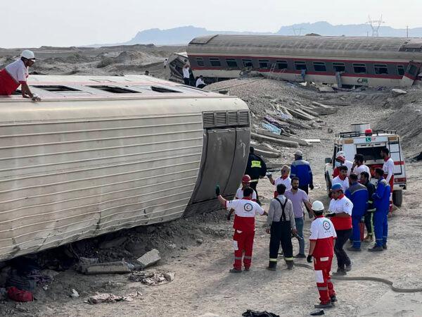 Rescuers work at the scene where a passenger train partially derailed near the desert city of Tabas in eastern Iran, on June 8, 2022. (Iranian Red Crescent Society via AP)