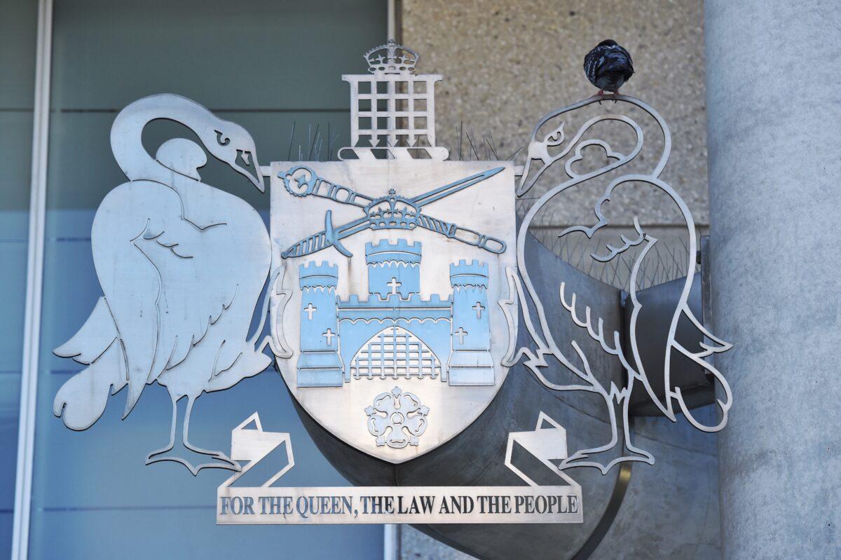 A pigeon sits on top of the Australian Capital Territory coat of arms outside the Magistrates Court in Canberra, Australia, on Feb. 16, 2016. (AAP Image/Mick Tsikas)