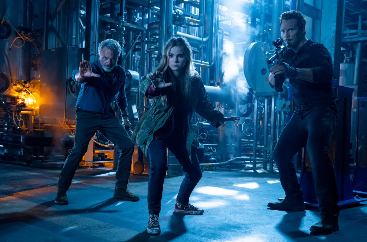 (L–R) Sam Neill as Alan Grant, Isabella Sermon as Maisie Lockwood, and Chris Pratt as Owen Grady do the warding-off-of-velociraptors gesture in "Jurassic World: Dominion." (Amblin Entertainment/Universal Pictures)