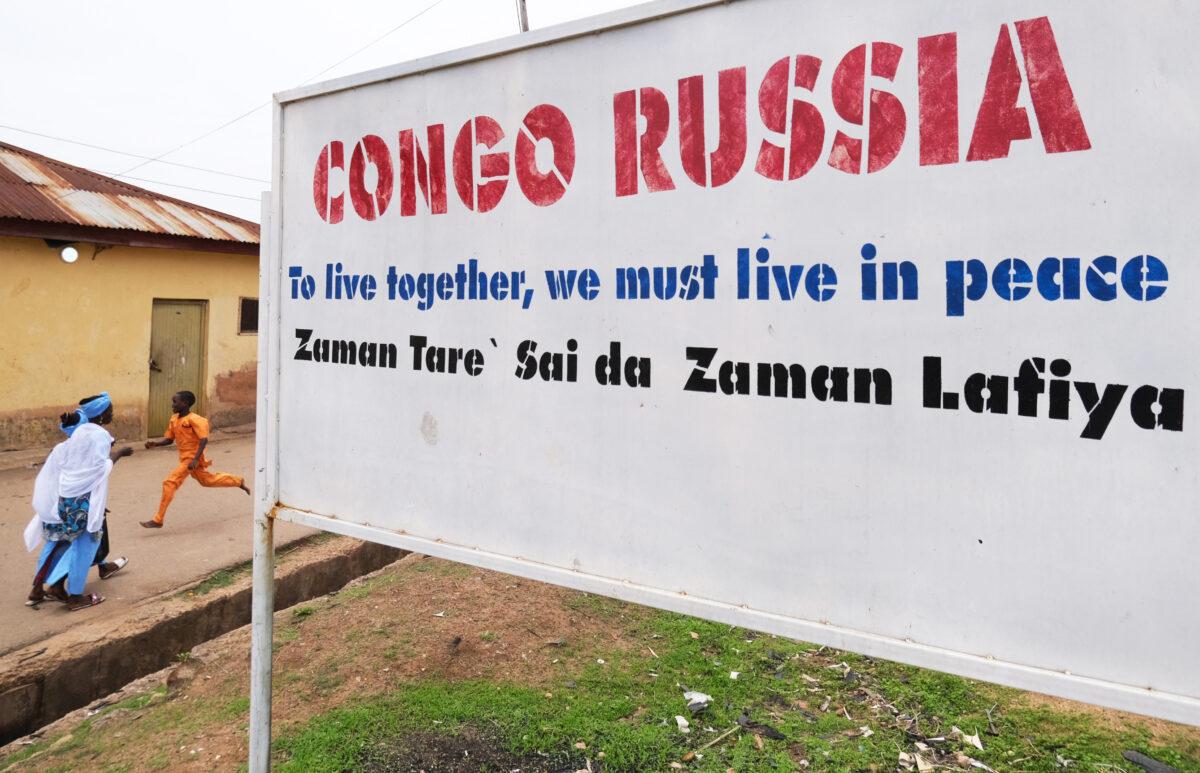 People walk past a street sign in one of the most violent flashpoints in Congo-Russia Road in Jos, Nigeria, on May 15, 2021. For years, the central city of Jos was a flashpoint for ethnic strife pitting Christian and Muslim youth against each other in clashes in their rival neighbourhoods. But community leaders have turned to football and music as a way to reach across the divide in a programme successfully building trust and restoring the peace. (Kola Sulaimon/AFP via Getty Images)