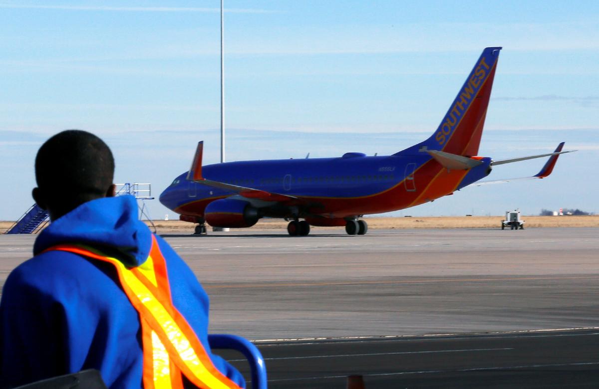 A luggage handler watches a departing Southwest Airlines Boeing 737–700 jet at Denver International Airport on Jan. 22, 2014. (Rick Wilking/Reuters)