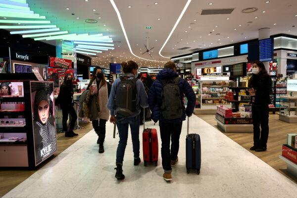 Passengers walk inside a duty-free shop at Paris Charles de Gaulle airport in Roissy-en-France, near Paris, on Dec. 2, 2021. (Sarah Meyssonnier/Reuters)