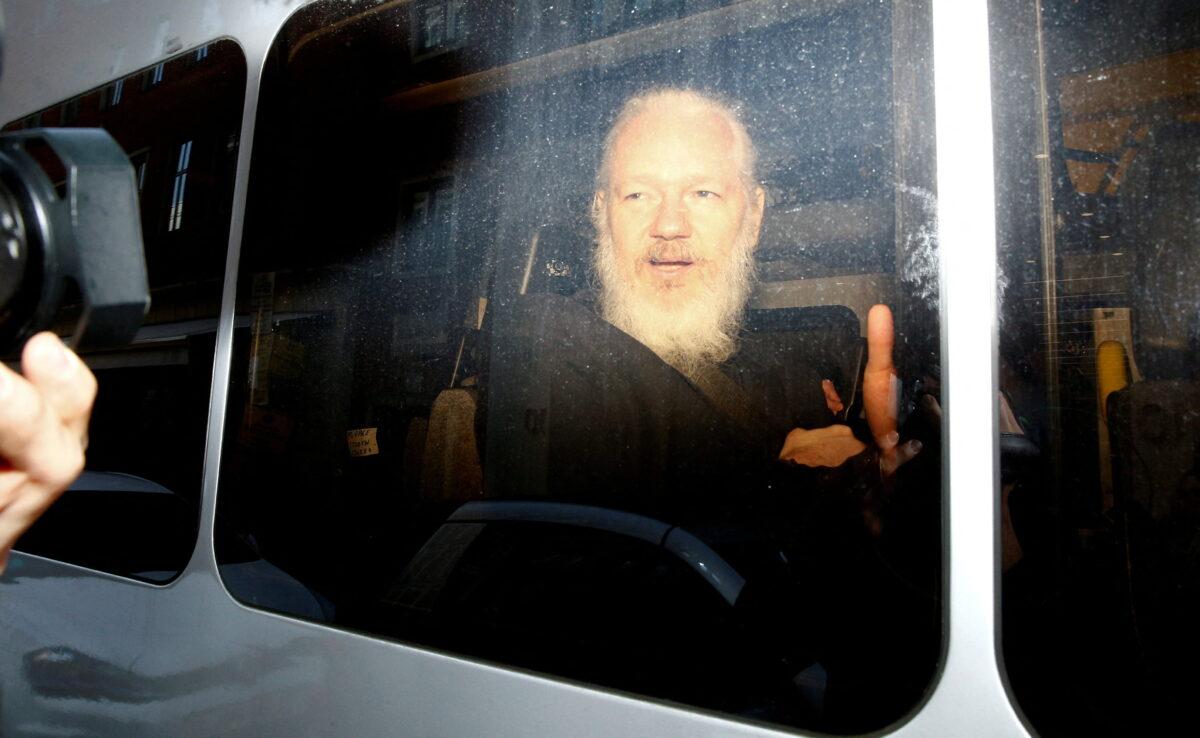 WikiLeaks founder Julian Assange is seen in a police van, after he was arrested by British police, in London on April 11, 2019. (Henry Nicholls/Reuters)