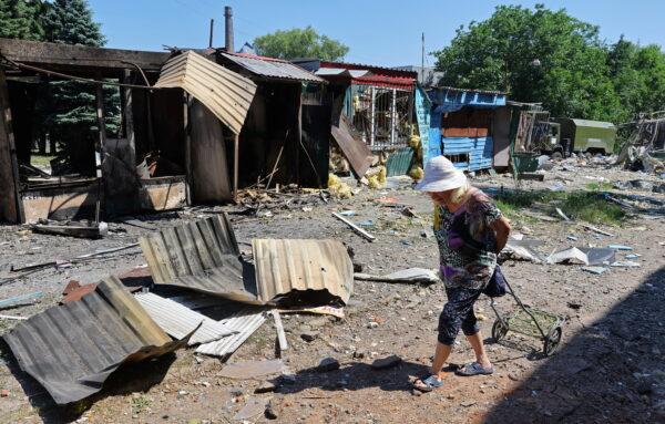 A woman walks past destroyed structures at a local market following recent shelling in the course of Ukraine-Russia conflict in Donetsk, Ukraine, on June 19, 2022. (Alexander Ermochenko/Reuters)