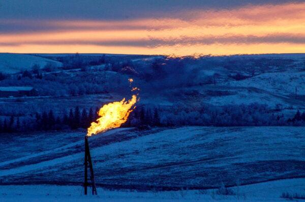 A natural gas flare on an oil well pad burns as the sun sets outside Watford City, N. Dak., on Jan. 21, 2016. (Andrew Cullen/Reuters)