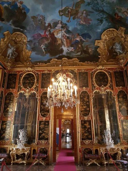 Gold-shining stucco decorations frame decorative Chinese panels and large mirrors in what once was a royal restroom. Designed by Filippo Juvarra, this Rococo restroom features a painted ceiling of a landscape scene, which centrally lifts into the sky with floating mythical figures. (Ambra75/CC BY-SA 4.0)