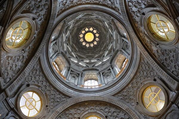 The otherworldly interior of the Chapel of the Holy Shroud showcases the beautiful patterning on the dome's inner walls. Spiraling layers of marble build to a central golden point in the tower far above; a dove at its center represents the Holy Spirit. The chapel’s architect Guarino Guarini was a mathematician and a priest. Guarini’s devotion to creating architecture of mathematical and religious significance is evident in this masterwork of form and light.  (Guilhem Vellut/CC BY 2.0)