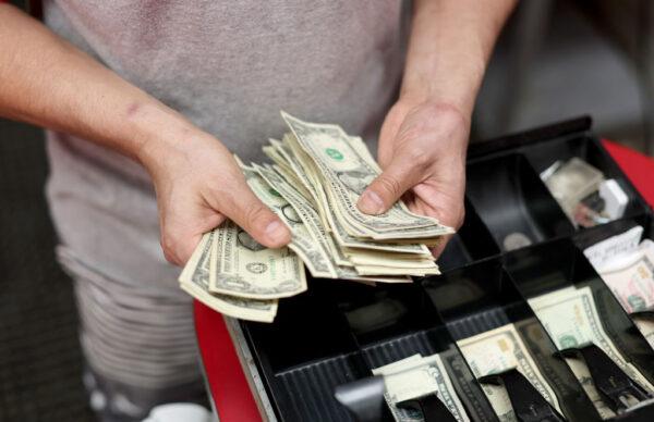 Edwin Lopez sorts the money in the cash register at Frankie's Pizza in Miami on Jan. 12, 2022. (Joe Raedle/Getty Images)