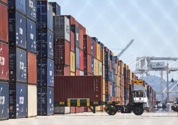 A truck drives by stacks of shipping containers at the Port of Oakland, California, on May 20, 2022. (Justin Sullivan/Getty Images)