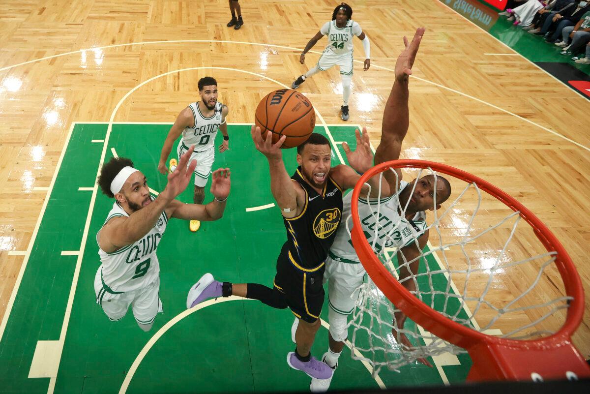 Golden State Warriors guard Stephen Curry (30) goes up for a shot against Boston Celtics center Al Horford (42) and guard Derrick White (9) during Game 4 of basketball's NBA Finals in Boston on June 10, 2022. (Kyle Terada/Pool Photo via AP)