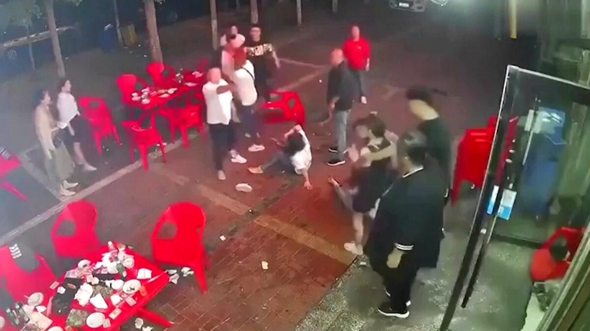 A group of men assault a woman outside a restaurant in the northeastern city of Tangshan, China, on June 10, 2022, in this screen grab taken from surveillance footage obtained by Reuters. (Reuters/Screenshot via The Epoch Times)