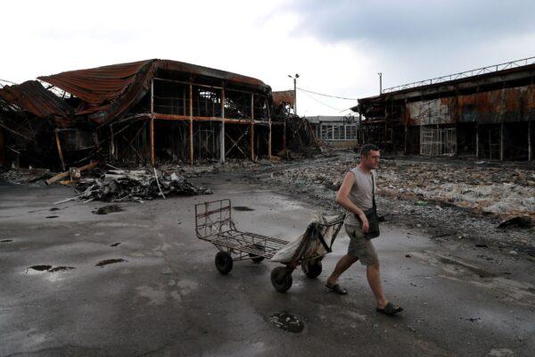 A man pulls a cart at the shelled Barabashovo market, in Kharkiv, Ukraine, on June 12, 2022. (Ivan Alvarado/Reuters)