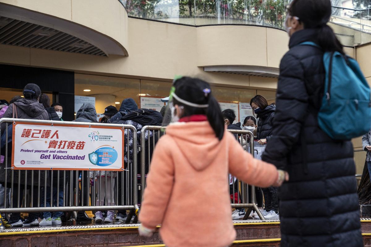 Residents queue outside a community vaccination center administering the Sinovac Biotech Ltd. Covid-19 vaccine to children and elderly ahead of its opening hours in Hong Kong, China, on Feb. 23, 2022. (Chan Long Hei/Bloomberg)