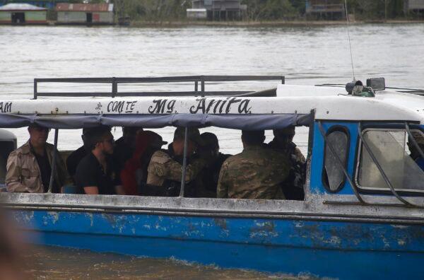 Federal police officers take a suspect towards the river where Indigenous expert Bruno Pereira and freelance British journalist Dom Phillips disappeared, in Atalaia do Norte, Amazonas state, Brazil, on June 15, 2022. (Edmar Barros/AP Photo)