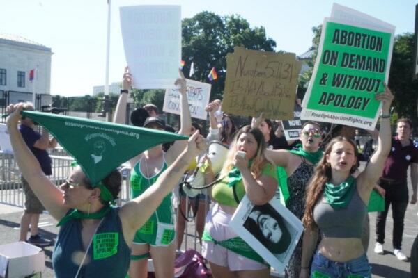Pro-abortion protesters with Rise Up 4 Abortion Rights wear green as they protest outside the U.S. Supreme Court on June 15, 2022. (Jackson Elliott/The Epoch Times)