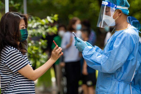 A health worker scans a local resident's phone during a COVID-19 test in Pudong District of Shanghai on June 11, 2022. (Liu Jin/AFP via Getty Images)