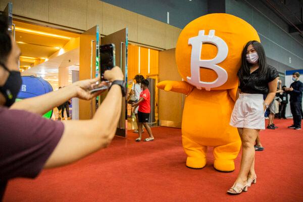 A woman poses with a bitcoin mascot during the Thailand Crypto Expo 2022 in Bangkok on May 14, 2022. The expo was held amid a global market crash. (Lauren DeCicca/Getty Images)
