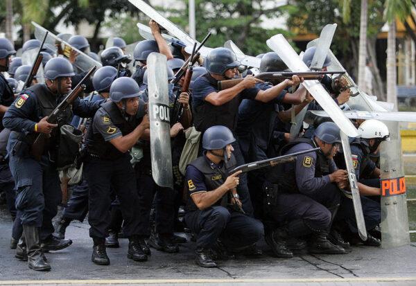 Policemen protect themselves with their shields as they try to disperse a demonstration of students who protest against the constitutional reform promoted by Venezuelan President Hugo Chavez in Caracas, Venezuela, on Nov. 1, 2007. (Juan Barreto/AFP via Getty Images)