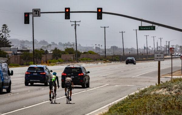 Cyclists ride along the Pacific Coast Highway in Huntington Beach, Calif., on May 20, 2021. (John Fredricks/The Epoch Times)