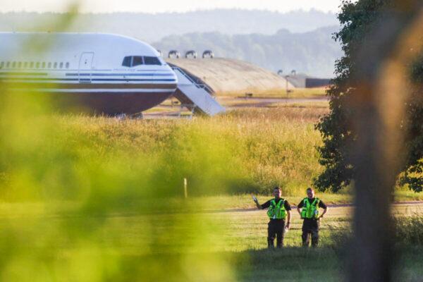 Police officers stand near a plane reported by British media to be first to transport illegal immigrants to Rwanda at MoD Boscombe Down base in Wiltshire, Britain, on June 14, 2022. (Hannah McKay /Reuters)