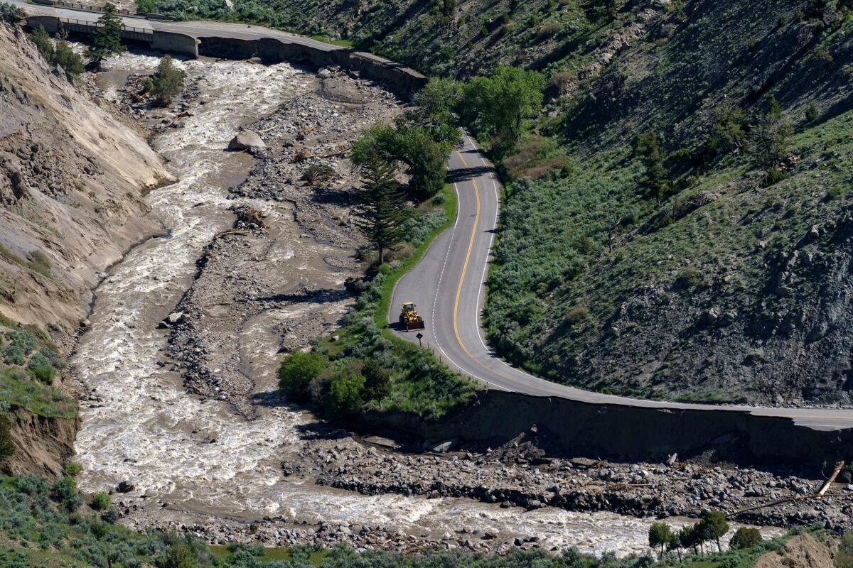 A bulldozer sits on North Entrance Road surrounded by sections washed away by recent floodwaters at Yellowstone National Park in Gardiner, Mont., on June 16, 2022. (David Goldman/AP Photo)