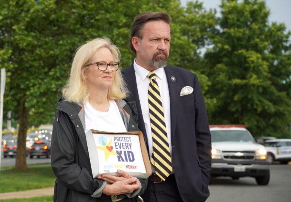 Sebastian Gorka with his wife, Katharine, at a parents’ rally outside the Luther Jackson Middle School in Falls Church, Va., on June 16, 2022. (Terri Wu/The Epoch Times)