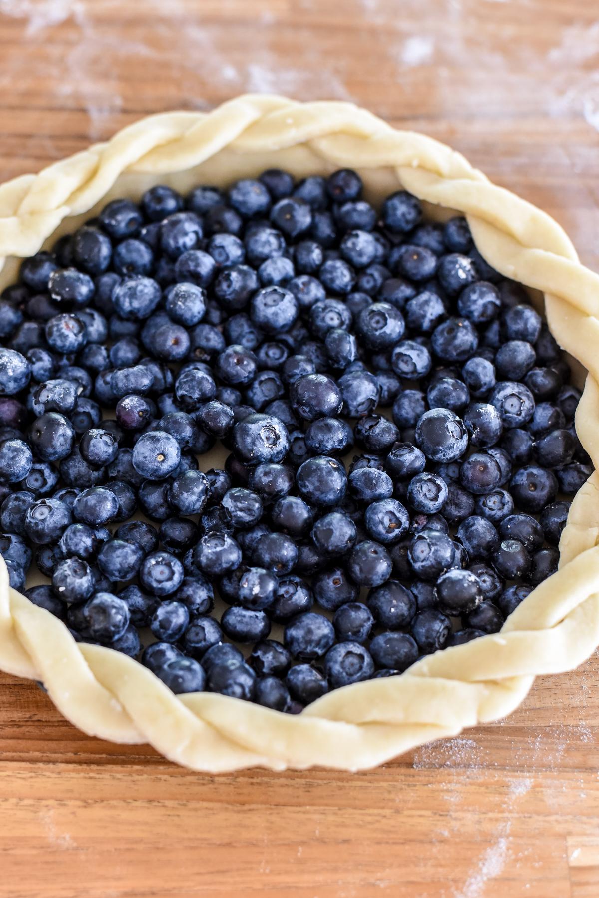 Transfer the rolled-out crust to the tart pan and evenly scatter with blueberries. (Audrey Le Goff)