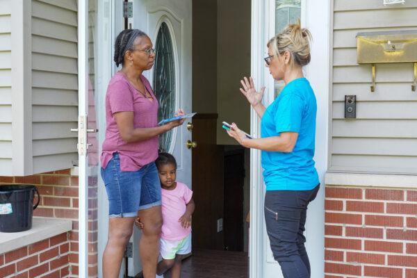 Jackie McGowan talks to a registered Democat in an African American majority neighborhood on the west side of Peoria, IL on June 11, 2022. (Cara Ding/The Epoch Times)