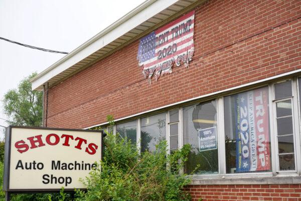 John Shotts still keeps his Trump flags hung on the wall of his auto repair business in Galesburg, lll., on June 7, 2022. (Cara Ding/The Epoch Times)