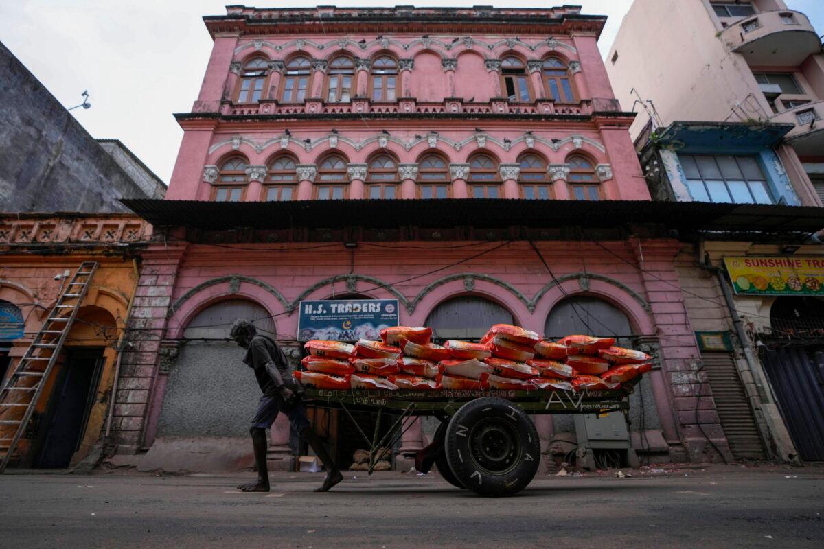 A laborer pulls a cartload of imported rice at a wholesale market in Colombo, Sri Lanka, on June 26, 2022. Sri Lankans have endured months of shortages of food, fuel, and other necessities due to the country's dwindling foreign exchange reserves and mounting debt, worsened by the pandemic and other longer-term troubles. (AP Photo/Eranga Jayawardena)