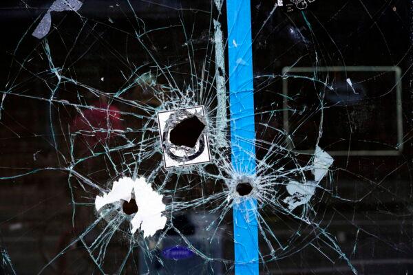 Bullet holes from a prior shooting are still present in a storefront window at the scene of a fatal overnight shooting on South Street in Philadelphia, on June 5, 2022. (Michael Perez/AP Photo)