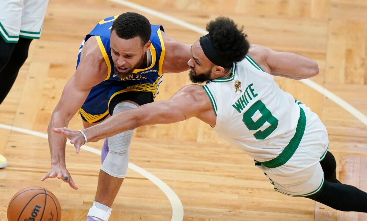 Boston Celtics guard Derrick White (9) and Golden State Warriors guard Stephen Curry (30) scramble for a loose ball during the first quarter of Game 6 of basketball's NBA Finals in Boston on June 16, 2022. (Steven Senne/AP Photo)