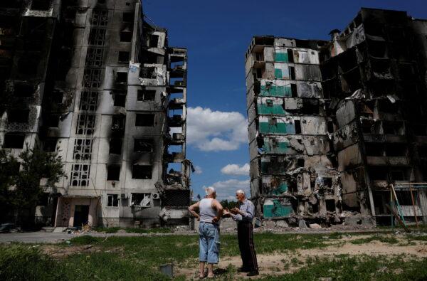 Residents chat in front of a destroyed building in Borodianka, as Russia's attacks on Ukraine continue, Kyiv Region, Ukraine, on June 4, 2022. (Edgar Su/Reuters)