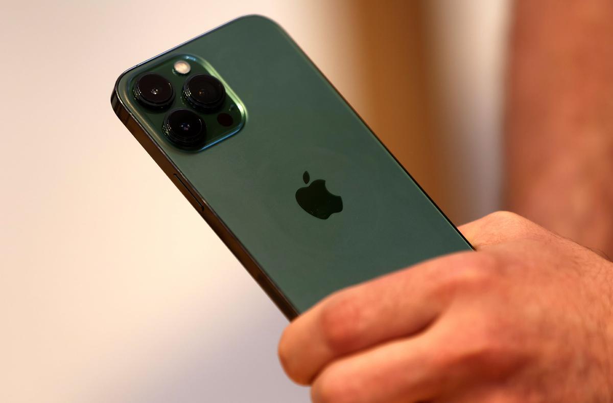 A customers holds the new green color Apple iPhone 13 pro, shortly after it went on sale inside the Apple Store on 5th Avenue in Manhattan, New York, on March 18, 2022. (Mike Segar/Reuters)