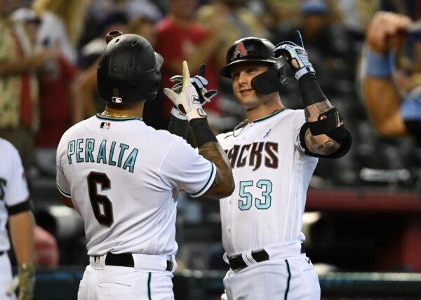 Christian Walker (53) of the Arizona Diamondbacks celebrates with David Peralta (6) after hitting a solo home run against the Minnesota Twins during the fourth inning at Chase Field in Phoenix on June 19, 2022. (Norm Hall/Getty Images)