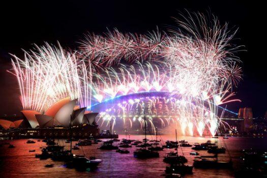 New Year's Eve fireworks light up the sky over Sydney's iconic Harbour Bridge and Opera House (L) during the fireworks show on Jan. 1, 2022. (David Gray/AFP via Getty Images)